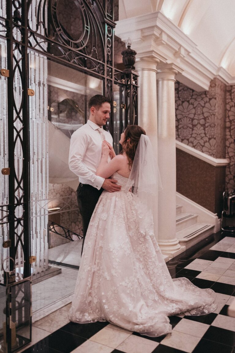 A bride and groom on the chequered marble floor of the stair hall, beside the lift-shaft ironwork, The Roseate Reading