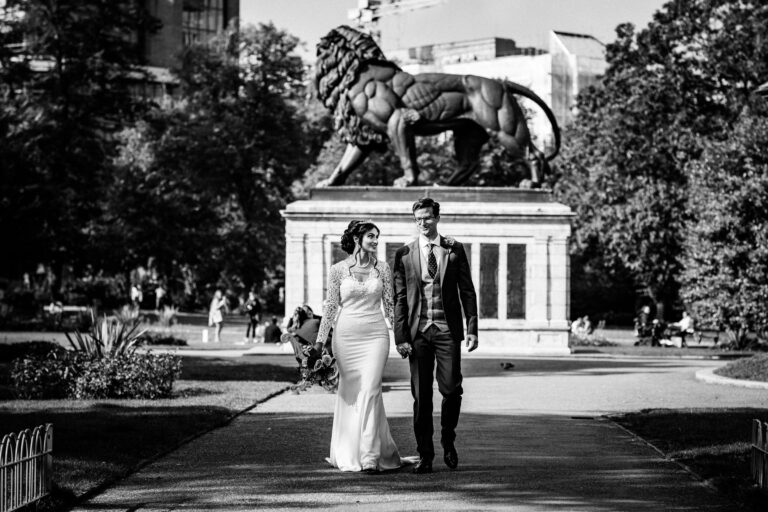 A couple walking in Forbury Gardens in front of the Maiwand Lion memorial, a short walk from the hotel, The Roseate Reading