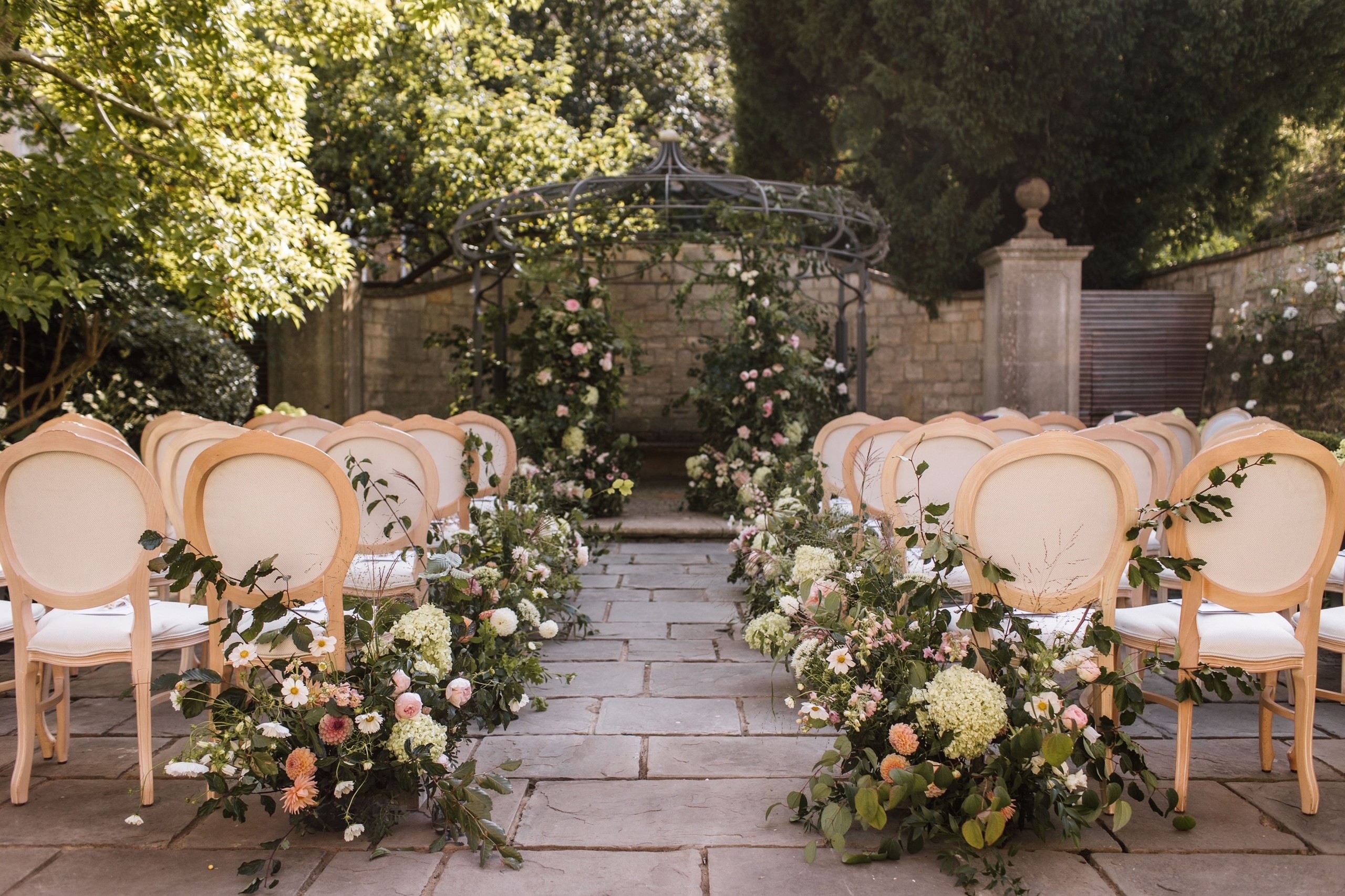 Chairs and flowers set for a ceremony in the walled garden, The Royal Crescent Hotel & Spa