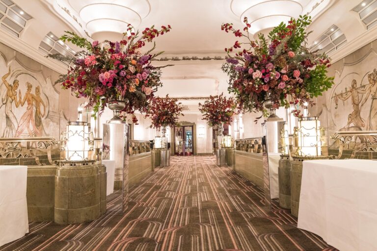 The Silver Gallery dressed for an event with tall urns of red and pink flowers, The Sheraton Park Lane Hotel