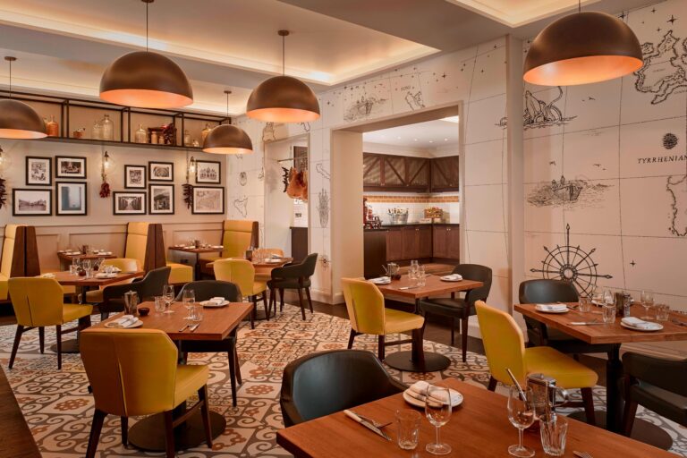 Mercante, the hotel's Italian restaurant, with mustard chairs, copper pendant lights and map murals, The Sheraton Park Lane Hotel