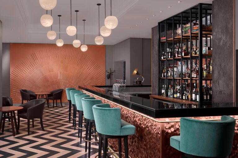 The Smith & Whistle bar with teal velvet stools, a copper sunburst wall and a zigzag floor, The Sheraton Park Lane Hotel