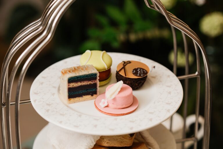 Pastries on the afternoon tea stand, including a layered cake and a pink mousse, The Sheraton Park Lane Hotel
