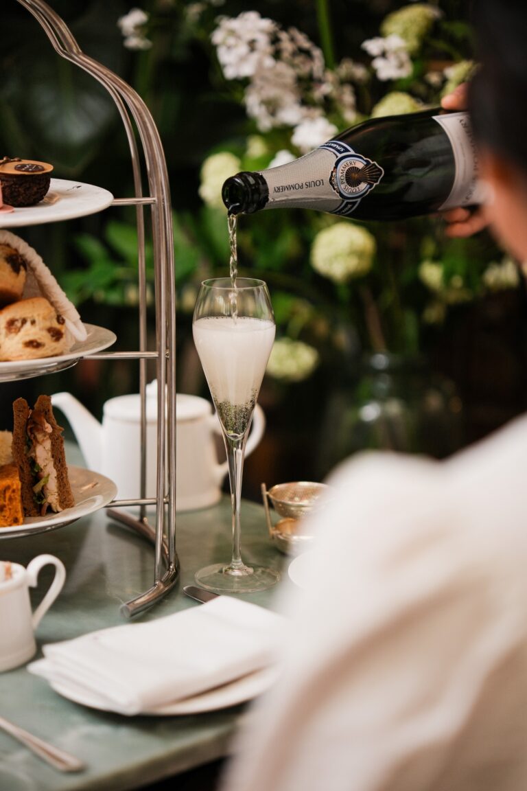 Champagne poured into a flute beside the afternoon tea stand, The Sheraton Park Lane Hotel
