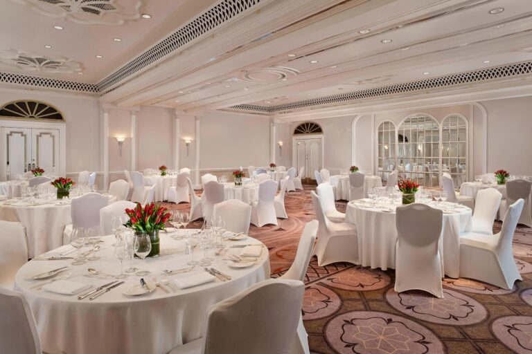 The Tudor Rose room laid for dinner with round tables and red tulip centrepieces, The Sheraton Park Lane Hotel