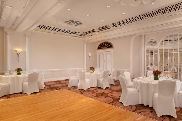The Tudor Rose with a wooden dance floor in front of round tables and mirrored arched windows, The Sheraton Park Lane Hotel