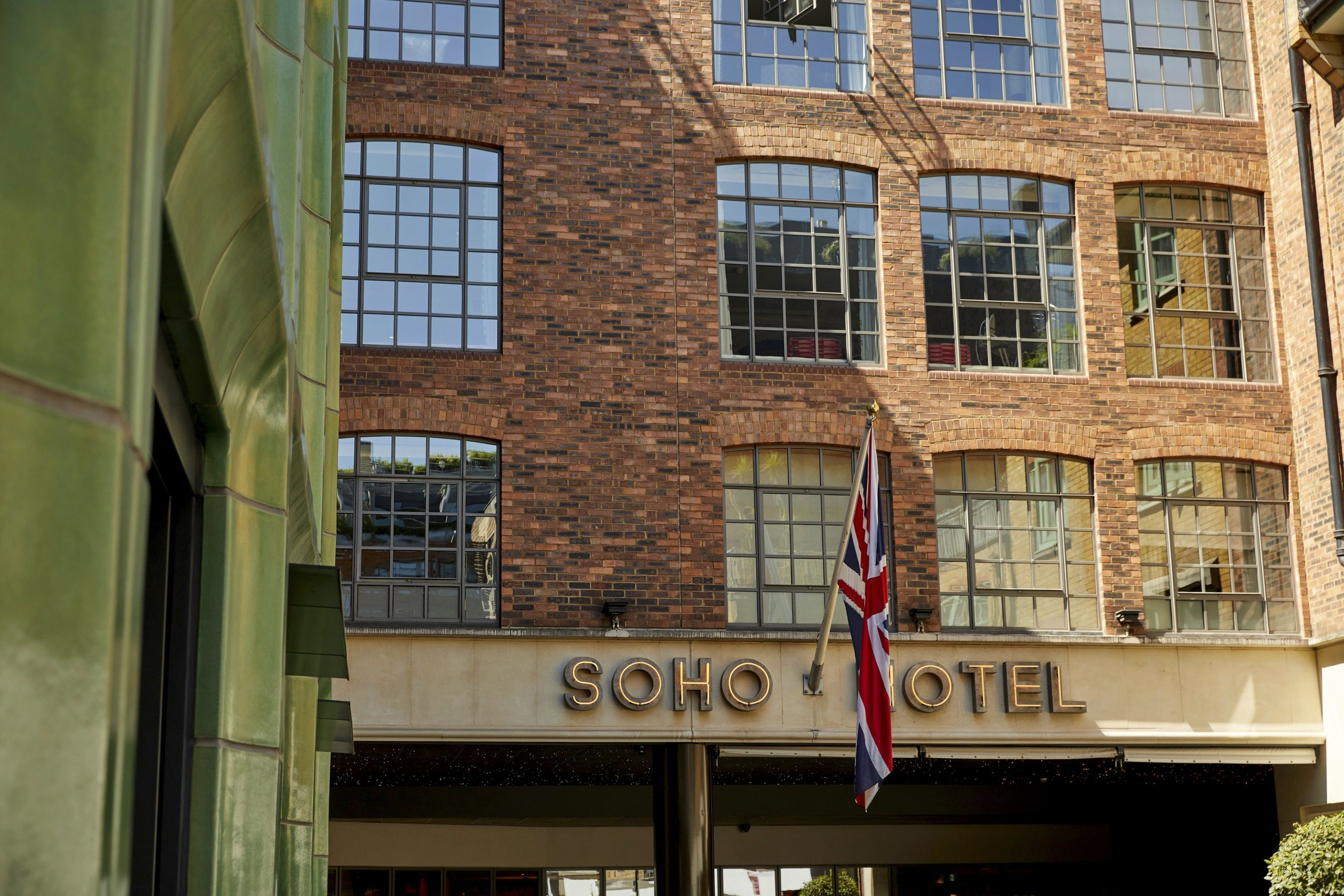The hotel entrance, with its brick facade and warehouse windows, The Soho Hotel