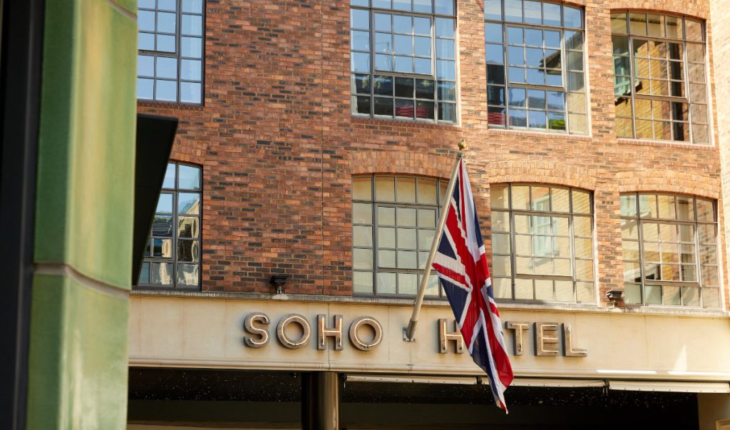 The Soho Hotel sign and Union flag above a brick facade with warehouse windows