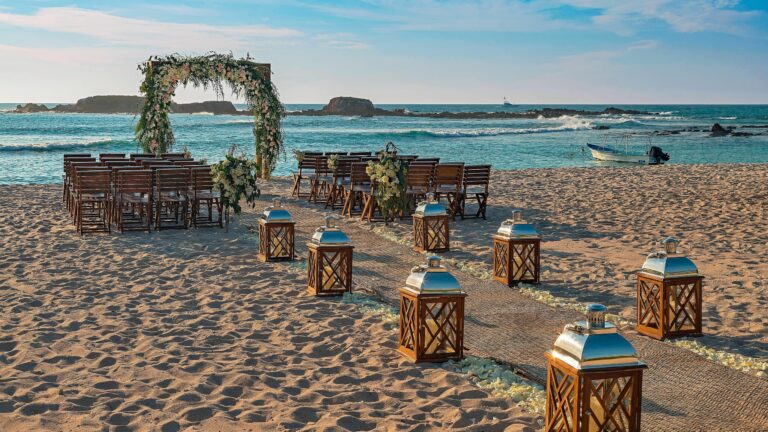 A beach ceremony aisle with a floral arch and lanterns, The St. Regis Punta Mita Resort