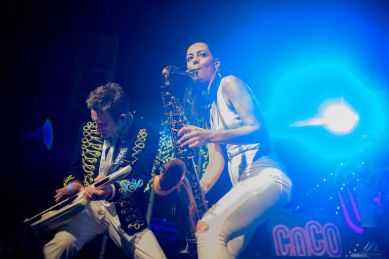 Saxophone and trumpet on stage with the COCO sign behind, The Sway Allstars