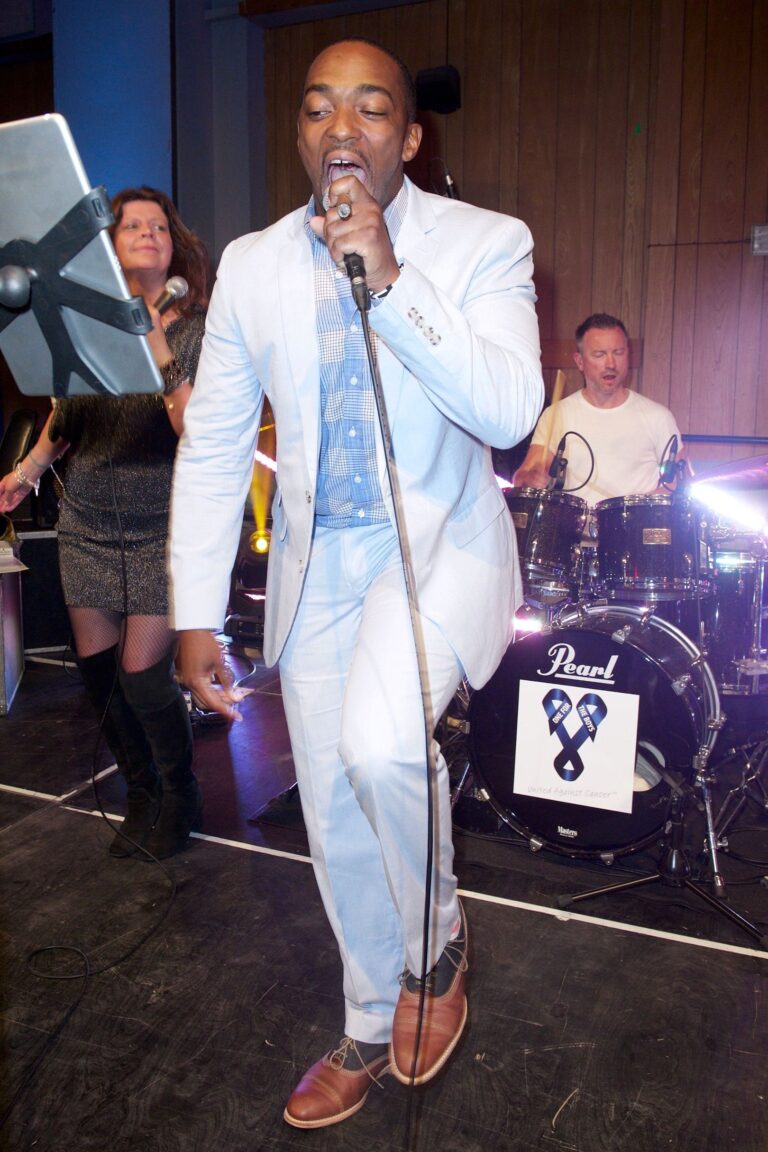 A singer in a pale suit with the drummer behind, The Sway Allstars