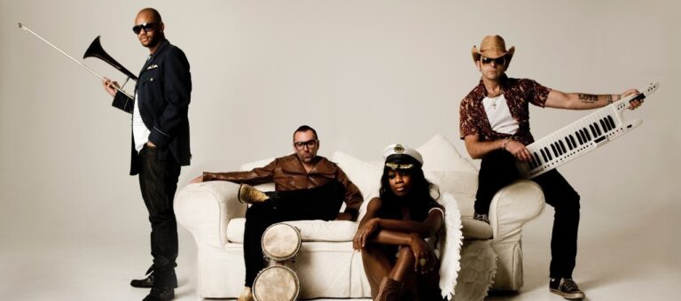 Four band members on a white sofa in a studio promotional photograph, The Sway Allstars