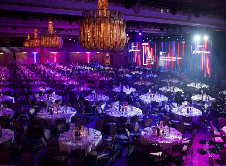 A ballroom set for a dinner with the band playing on stage, The Sway Allstars