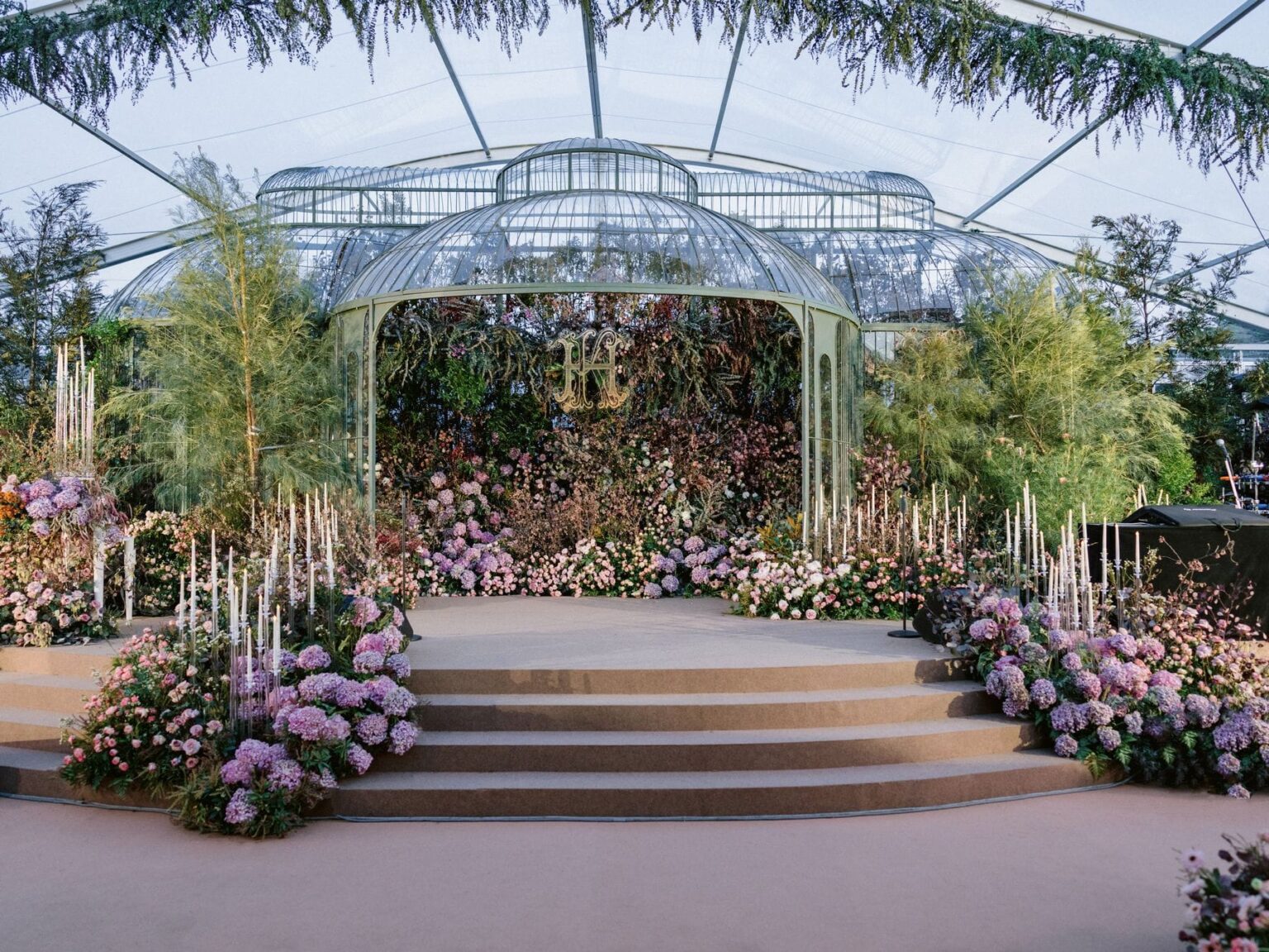 A glass-roofed marquee with a flower-dressed stage