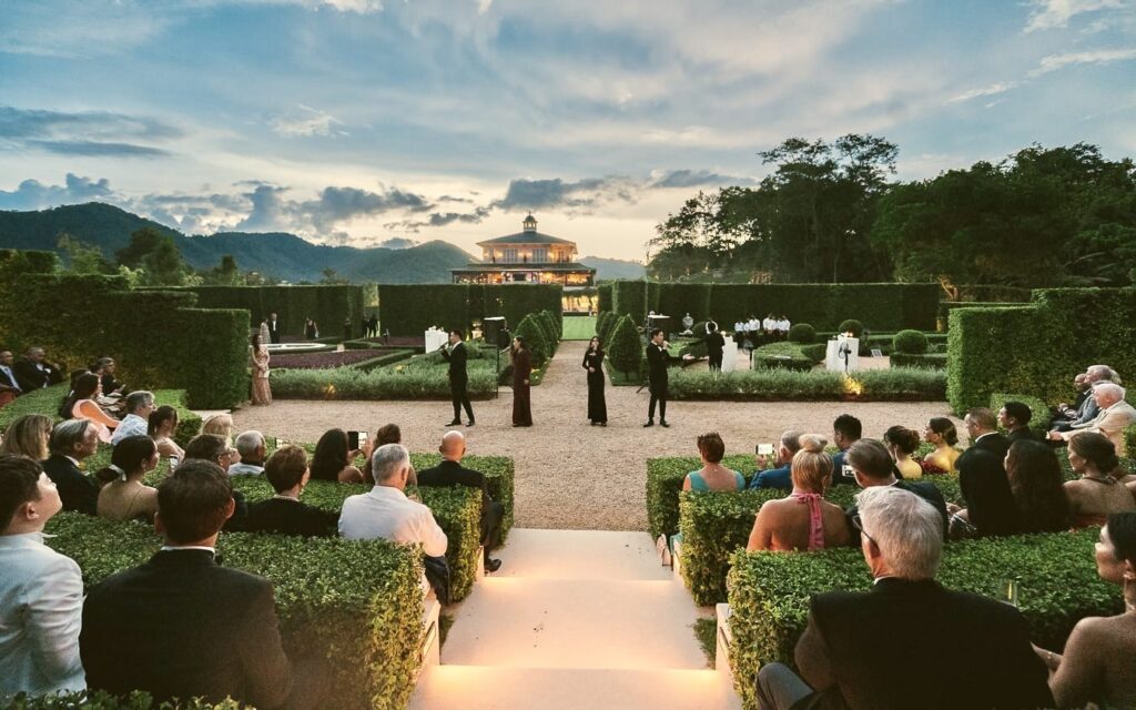 Guests seated along a white aisle in the Formal Garden