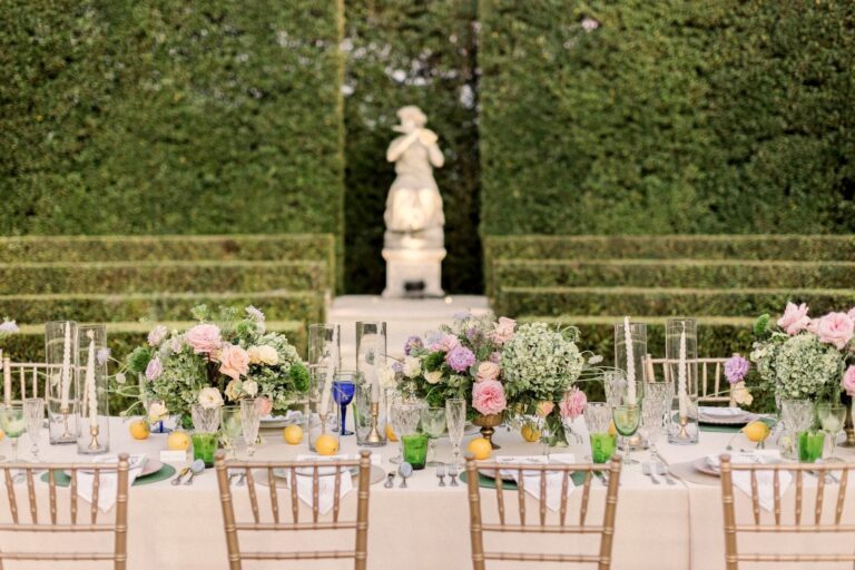 A long dinner table set in the Formal Garden before the hedges and statues, The Vanderbilt Estate
