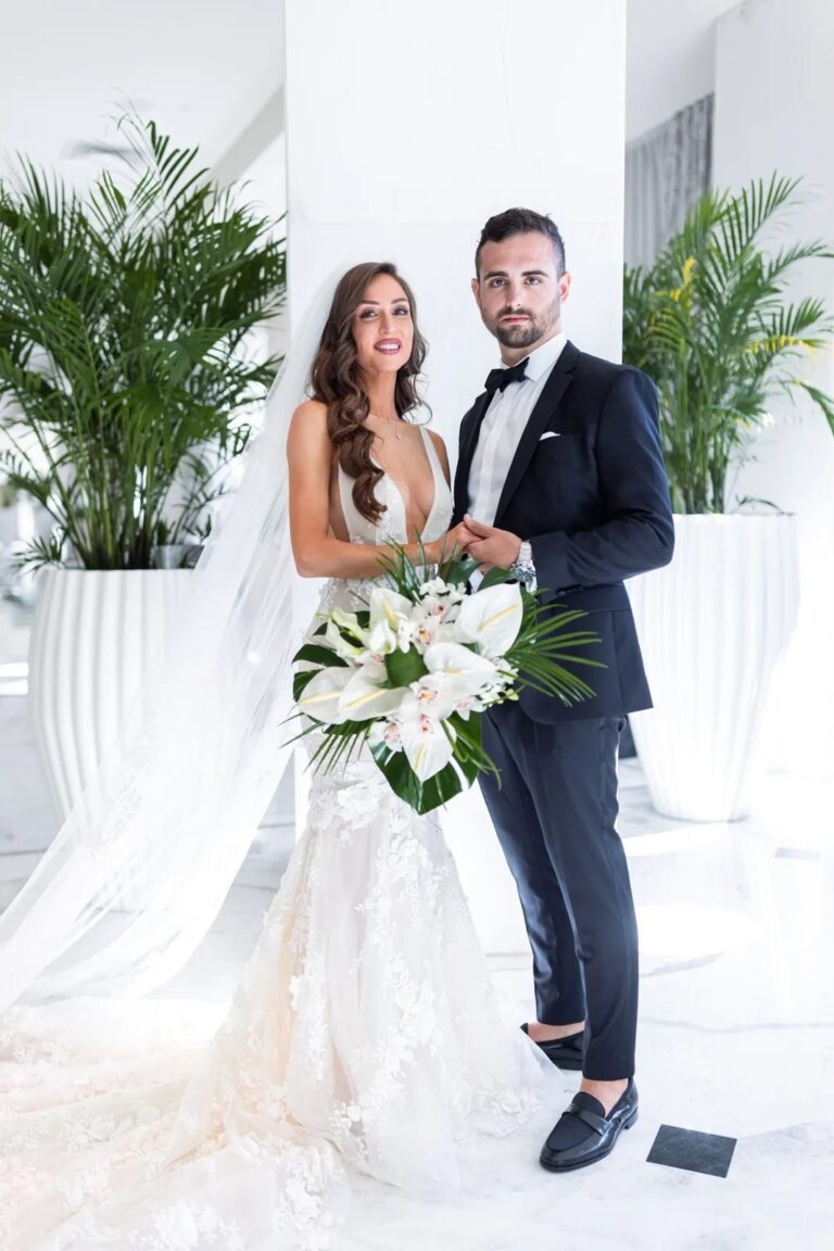 A couple standing among plants, The Wedding Atelier