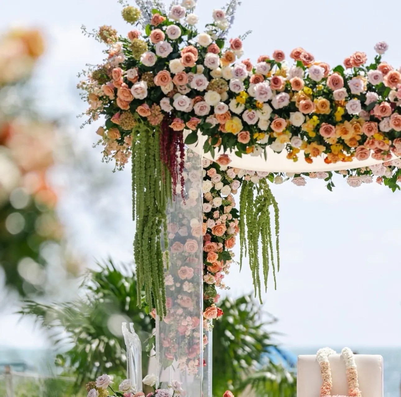 A floral ceremony arch in pink, peach and green, The Wedding Atelier