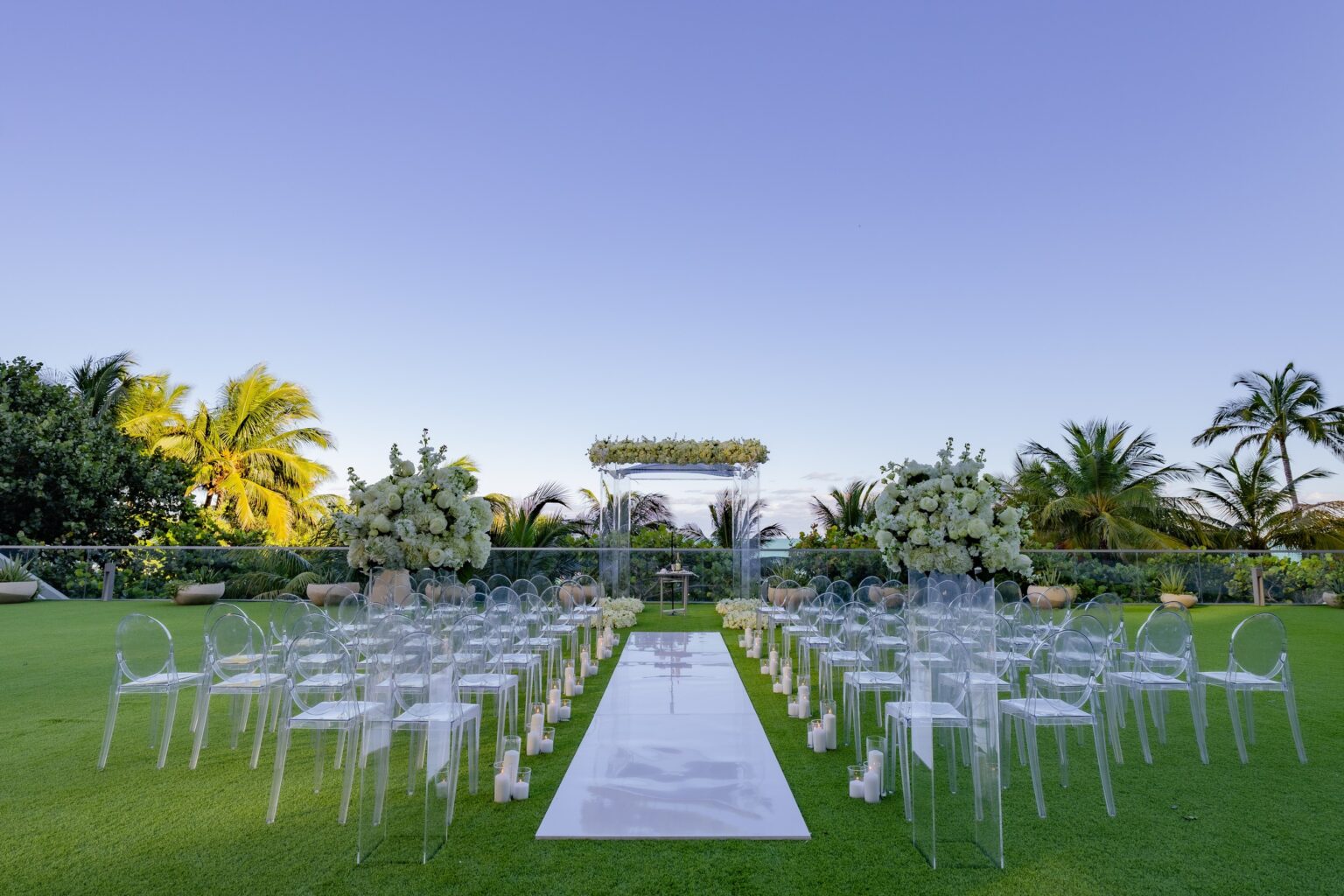 A lawn ceremony with white chairs and a mirrored aisle, The Wedding Atelier