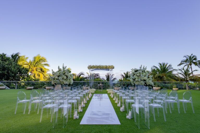 A lawn ceremony with white chairs and a mirrored aisle, The Wedding Atelier
