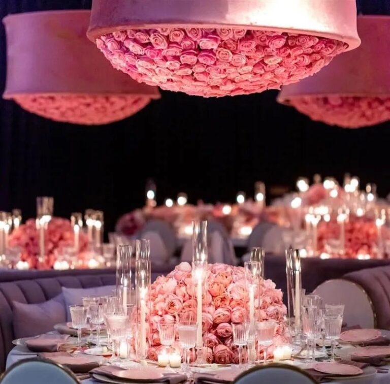 A round table set in pink under a floral canopy, The Wedding Atelier