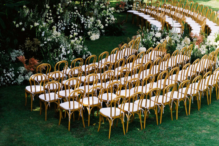 Curving rows of gold chairs on the lawn beside a flowering hedge, The Wedding Bliss - Thailand