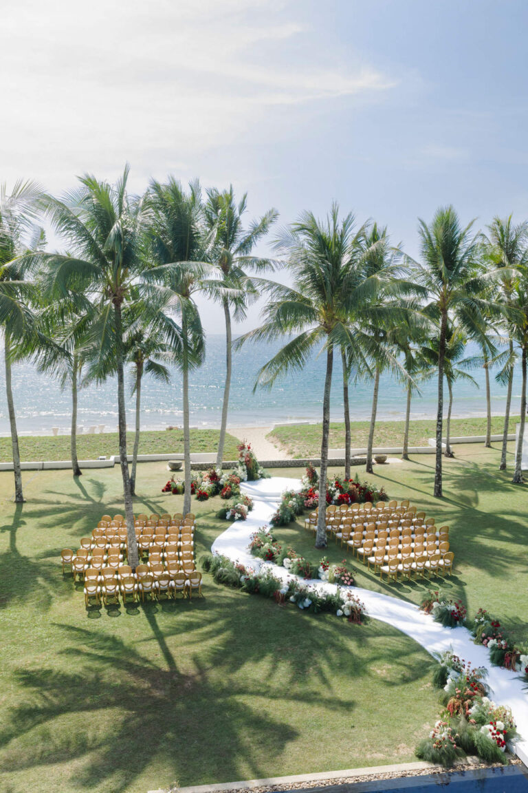 A white aisle curving through palms to seating by the sea, seen from above, The Wedding Bliss - Thailand