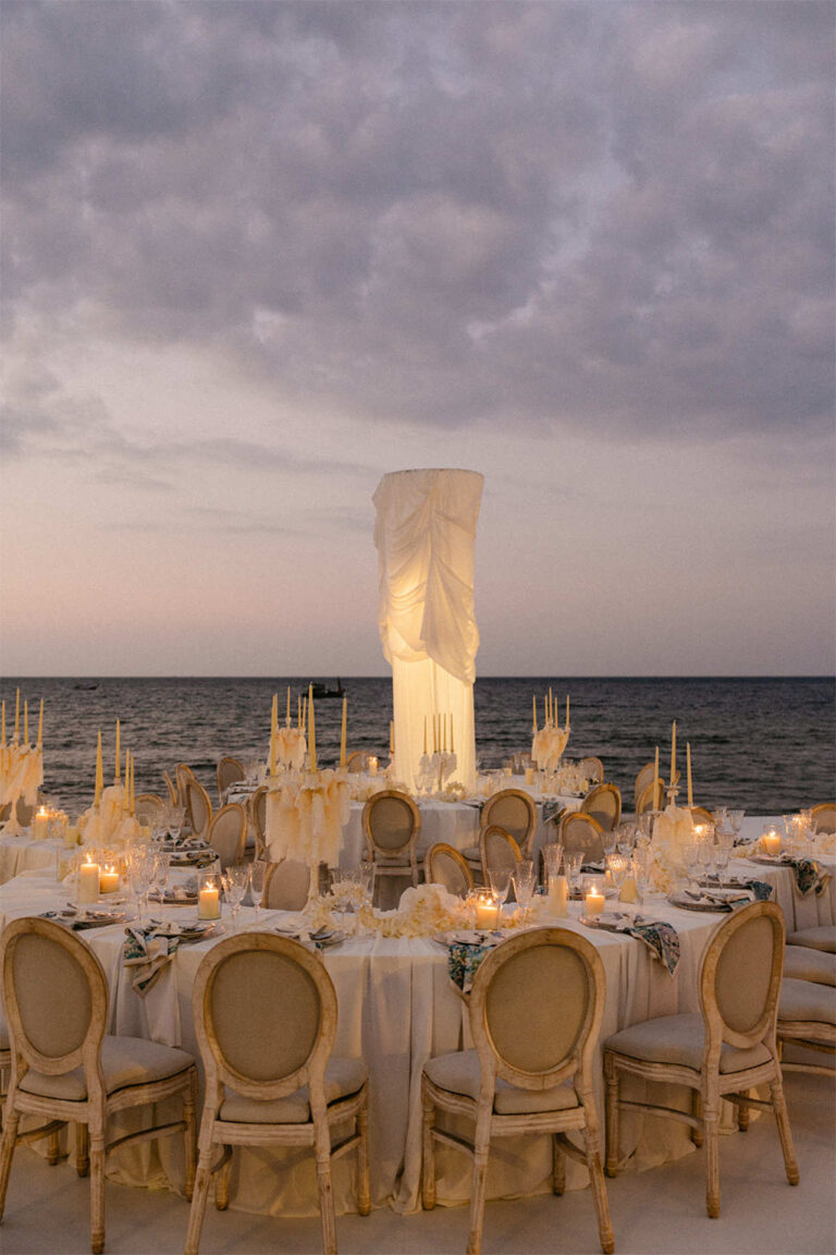 Round dinner tables on a platform beside the sea at dusk, The Wedding Bliss - Thailand