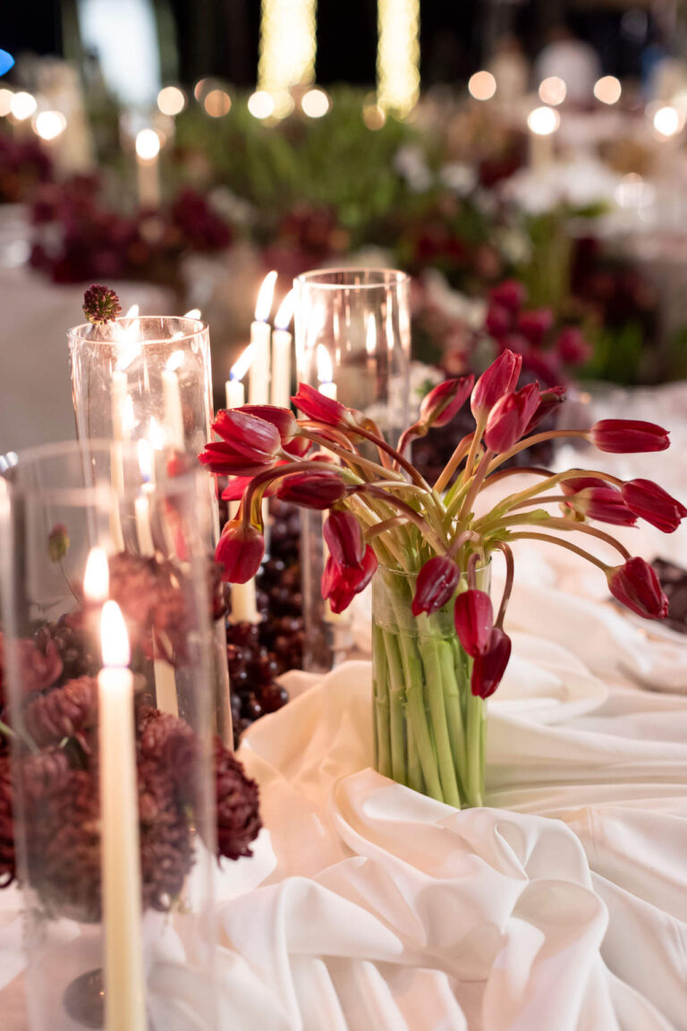 Tall candles and red tulips on a table dressed in white linen, The Wedding Bliss - Thailand