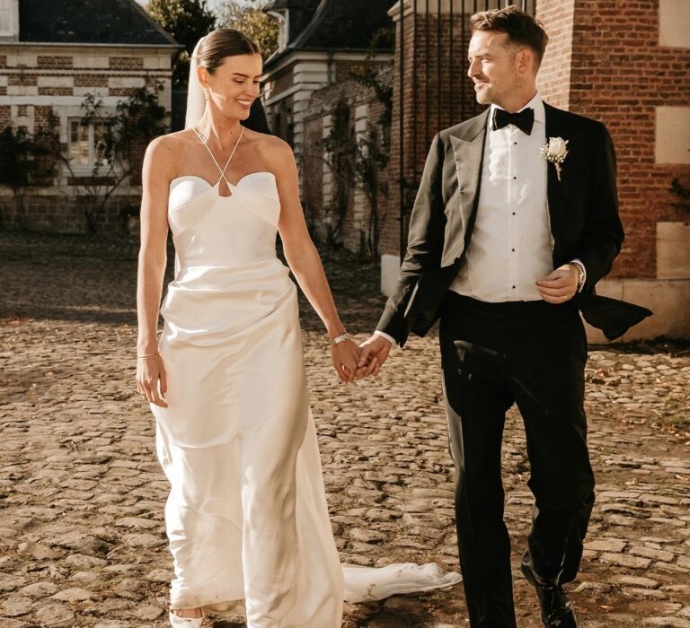 Rebecca and Jeremy walking hand in hand on their wedding day, The Wedding Shop