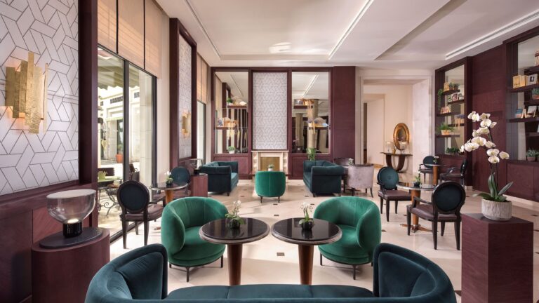 An elegant lounge with emerald velvet chairs and a geometric marble floor beside the garden, The Westin Valencia