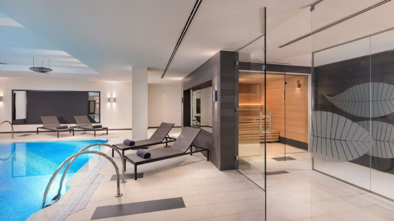 The spa, an indoor salt-water pool with loungers and a sauna beyond, The Westin Valencia