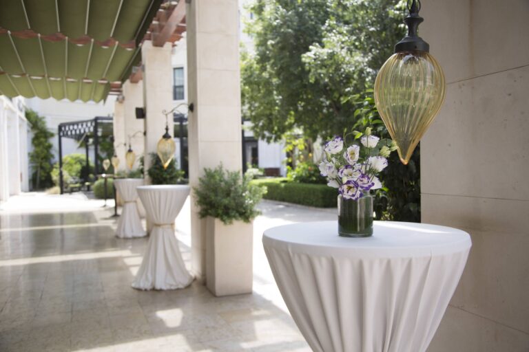 Cocktail poseur tables dressed in white with flowers along the garden portico, bougainvillea climbing the columns, The Westin Valencia