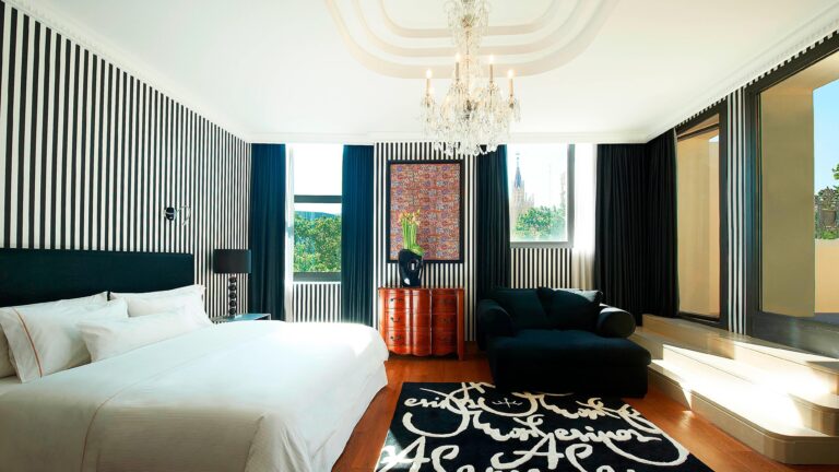 The Royal Suite bedroom, a crystal chandelier, striped walls and long views over the city, The Westin Valencia