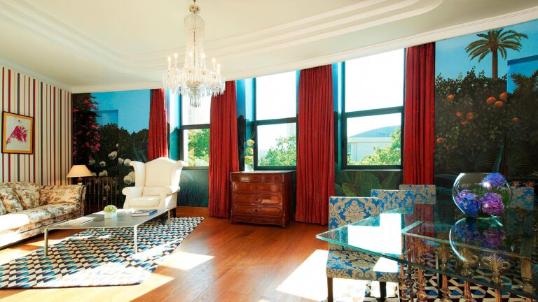 The Royal Suite living room, bright with painted garden murals, red drapes and city views, The Westin Valencia