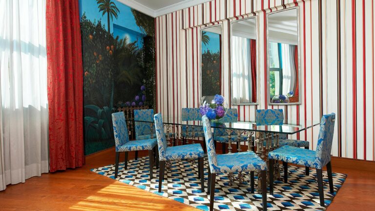 The Royal Suite dining room, striped walls, a painted mural and patterned blue chairs, The Westin Valencia
