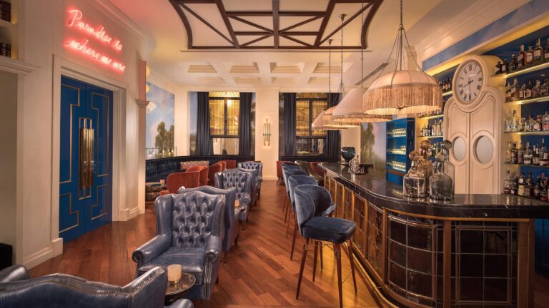 The cocktail bar, blue chesterfield chairs, brass and a curved counter beneath a decorative ceiling, The Westin Valencia