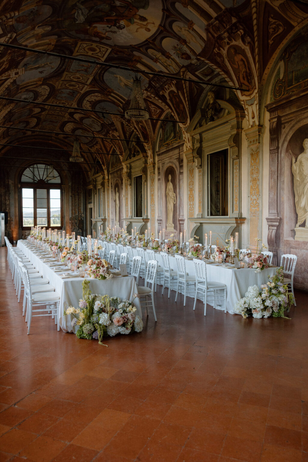 Long dinner tables in the frescoed gallery at Villa Corsini a Mezzomonte, Florence, TheKnotInItaly