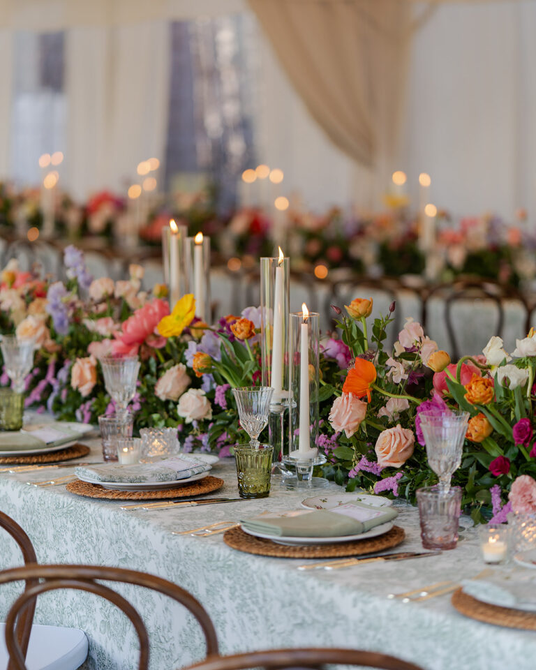 Reception tables with red, pink and orange flowers at Borgo Castelvecchio, Tuscany; decor by Stiatti Fiori, TheKnotInItaly