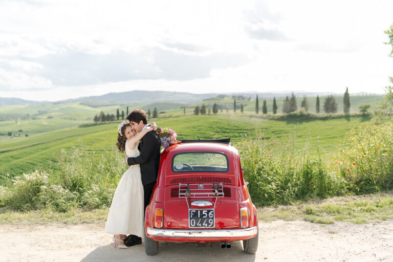 Emma and Donal with a red Fiat 500 in the Val d'Orcia countryside near Pienza, Tuscany, TheKnotInItaly