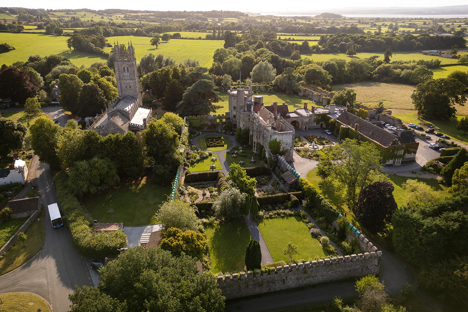 The castle, St Mary's Church and the walled gardens from above, with farmland running towards the Severn, Thornbury Castle