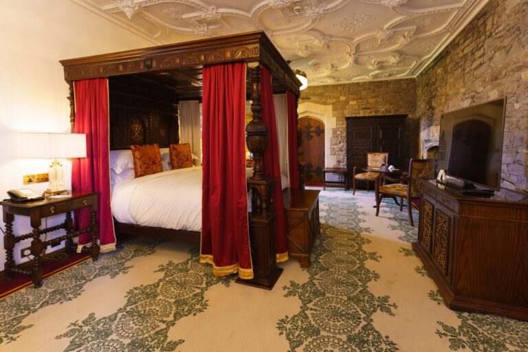 The Catherine Howard Superior Deluxe bedchamber with carved four-poster and red hangings, Thornbury Castle