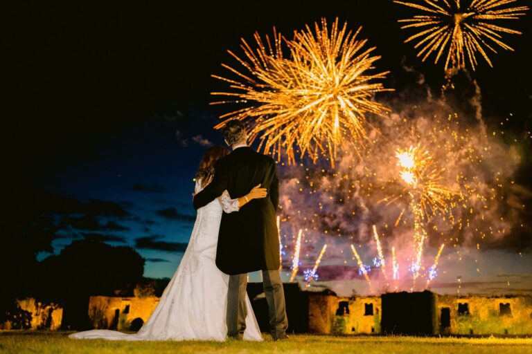 A couple watching fireworks over the floodlit castle walls, Thornbury Castle