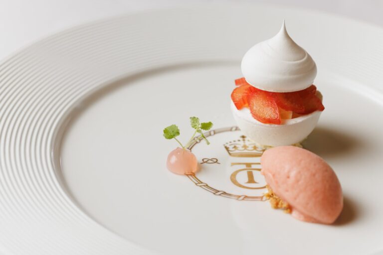 A strawberry and meringue dessert on a plate bearing the castle crest, Thornbury Castle