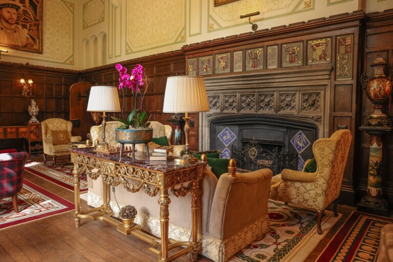A castle lounge with carved stone fireplace, orchids and period furniture, Thornbury Castle