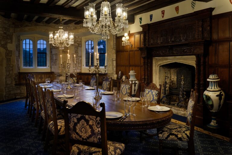 A panelled private dining room set for a long dinner by the fireplace, Thornbury Castle