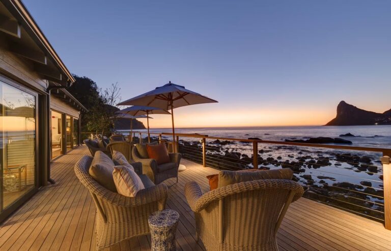 Sunset from the main lodge deck, lounge seating, the Sentinel silhouetted, Tintswalo Atlantic