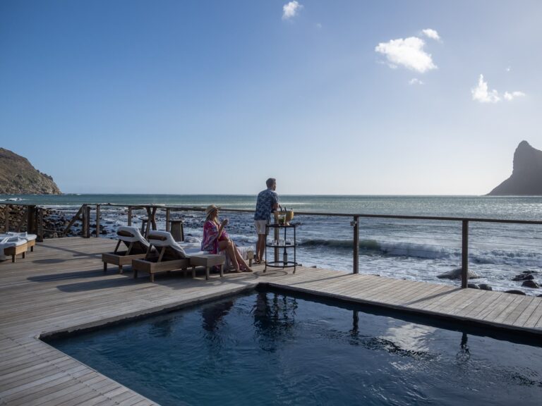 Guests on the pool deck looking out to sea, Tintswalo Lodges