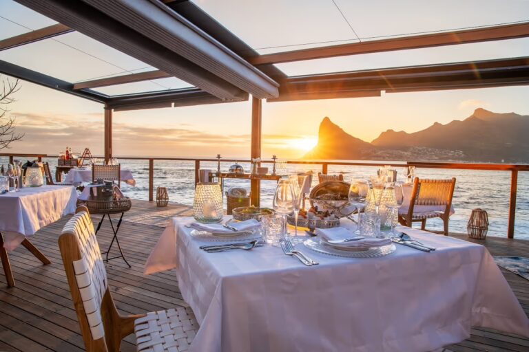 Table laid on the deck at sunset, Tintswalo Lodges