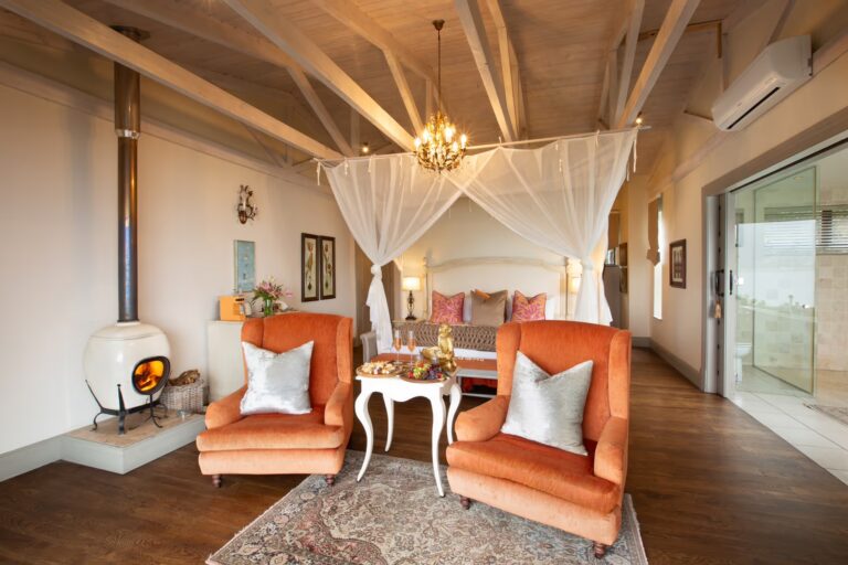 Mountain suite bedroom with a canopy bed and fireplace, Tintswalo Lodges